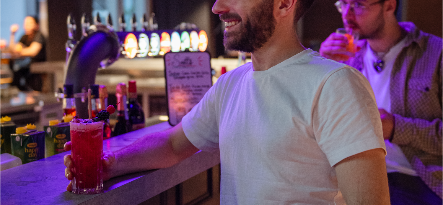 Un homme entrain de boire un cocktail au CyberBar d'Eva